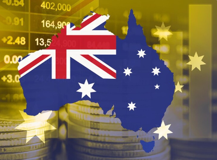 Illustration of the Australian flag shaped like the country's map, overlaid on a background of coin stacks and stock market data. The image symbolizes investment activity and financial growth on the Australian Stock Exchange.