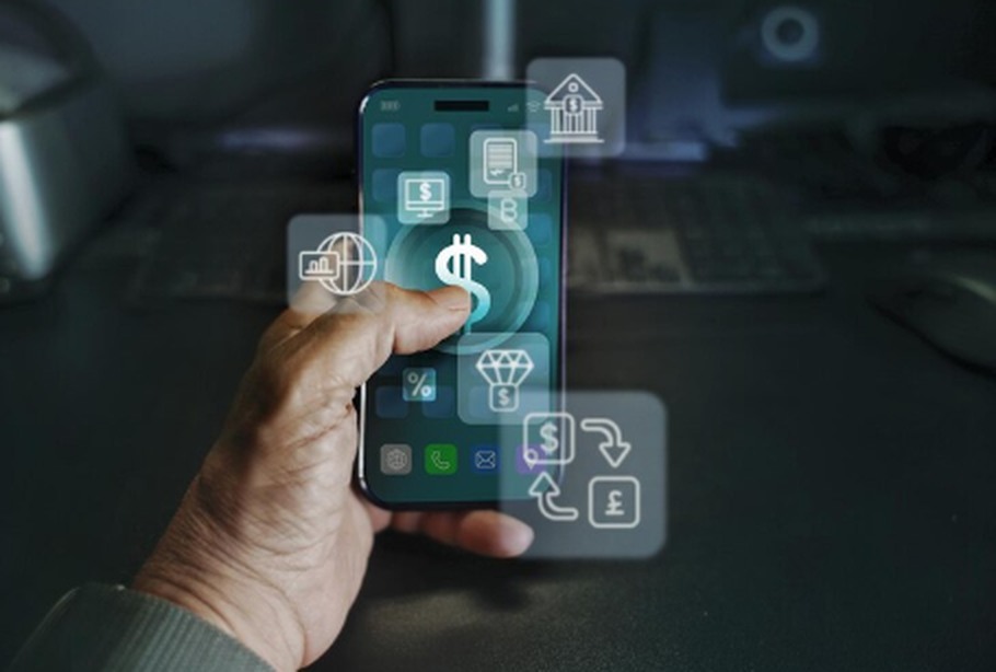 A hand interacts with a smartphone displaying financial app icons and digital overlays, symbolizing online transactions and investment features, representing the growing influence of digital banks in modern finance.