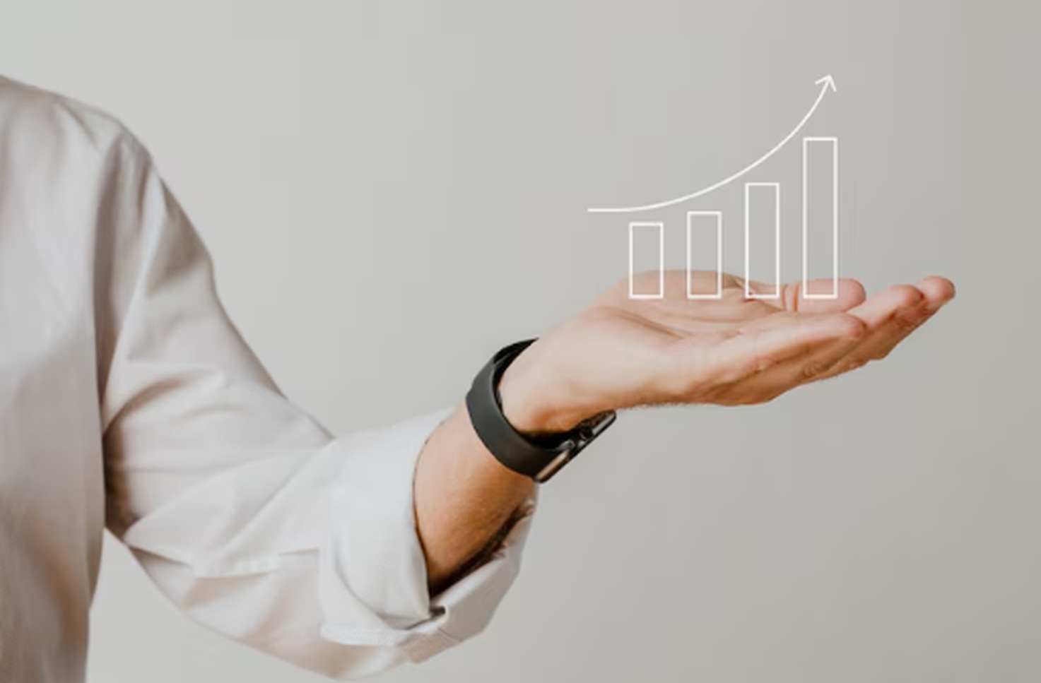 A person in a white shirt holding an open palm with a stylized upward-trending bar chart hovering above it, symbolizing growth, performance, and opportunity in the stock market.