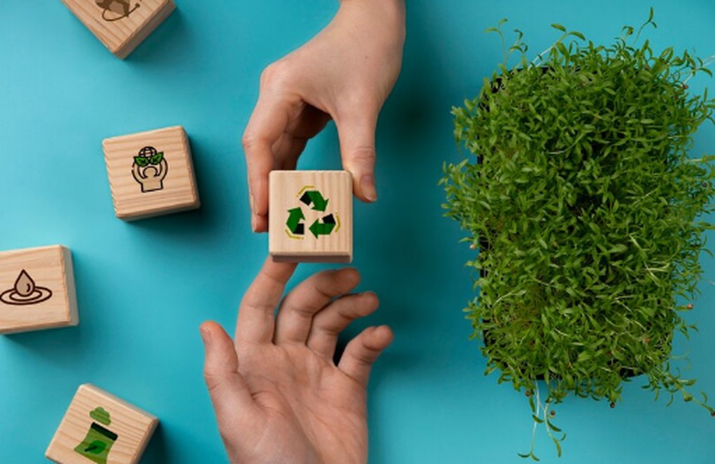 Two hands exchanging a wooden block with a green recycling symbol, surrounded by sustainability-themed icons and a small plant, representing the concept of sustainable investment and environmental responsibility.